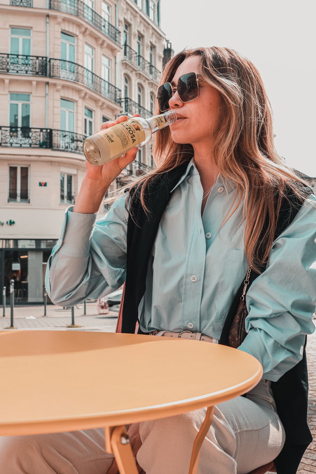 Une cliente boit une gazzosa italienne en terrasse