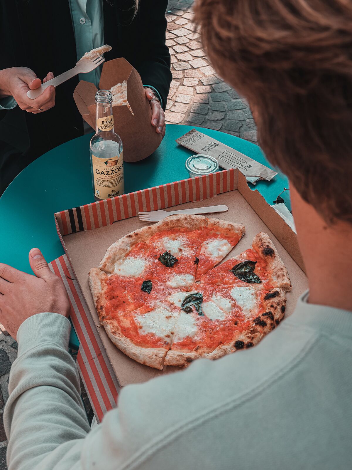 Une margherita ouverte dans son carton, sur une table de terrasse